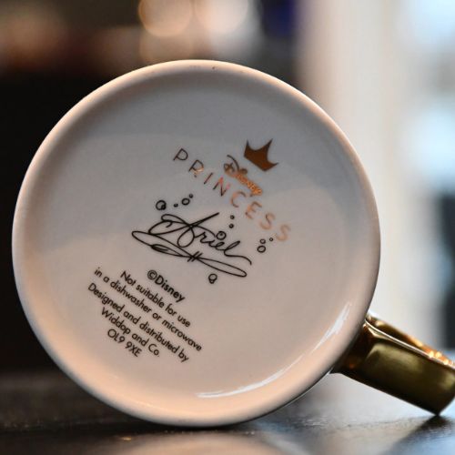 Undersiden av Aril koppen fra Disney. Gull skrift