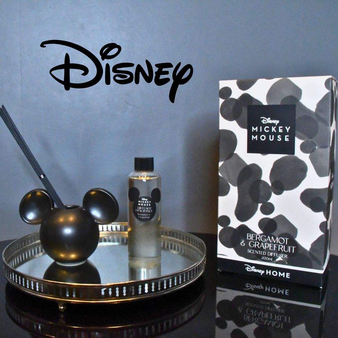 Viser hva som følger med produktet. En eske, en sort diffuser med pinner, og en liten flaske med duften man skal helle opp i diffuseren. Et lisensiert Disney produkt.