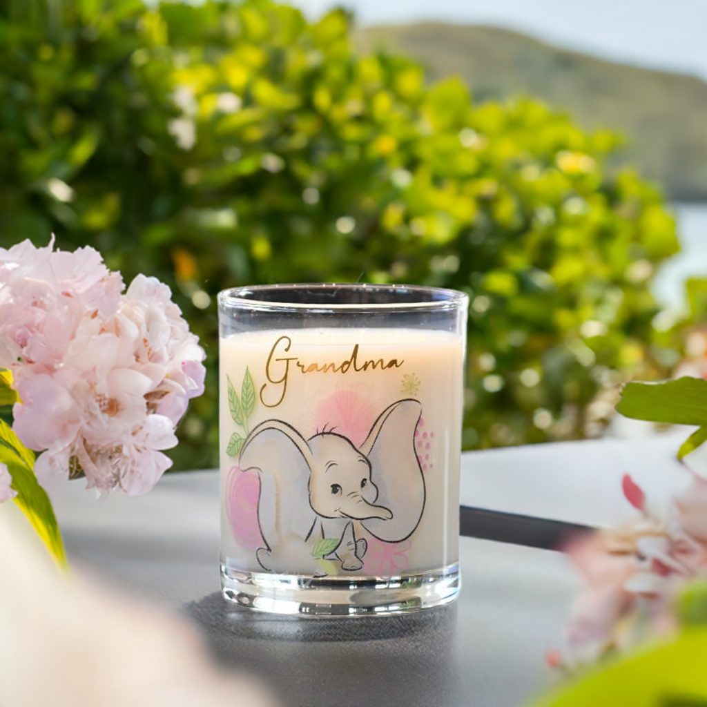 Grandma bestemor glasset fylt med melk ute i hagen. Nydelige farger og gullskrift på glasset som skinner i solen.