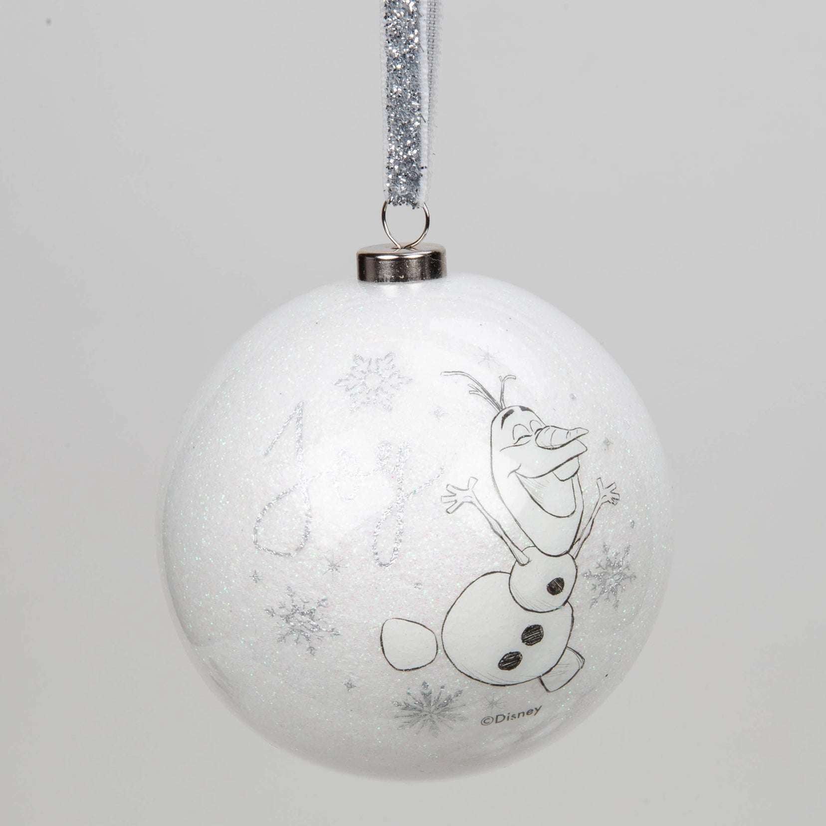 Disney julekule med Olaf. Hvit kule med snøre i sølv og glitter. Snømannen Olaf er fra den kjente Disney filmen Frost. Han hopper og er glad. Tegnet illustrasjon på julepynten.