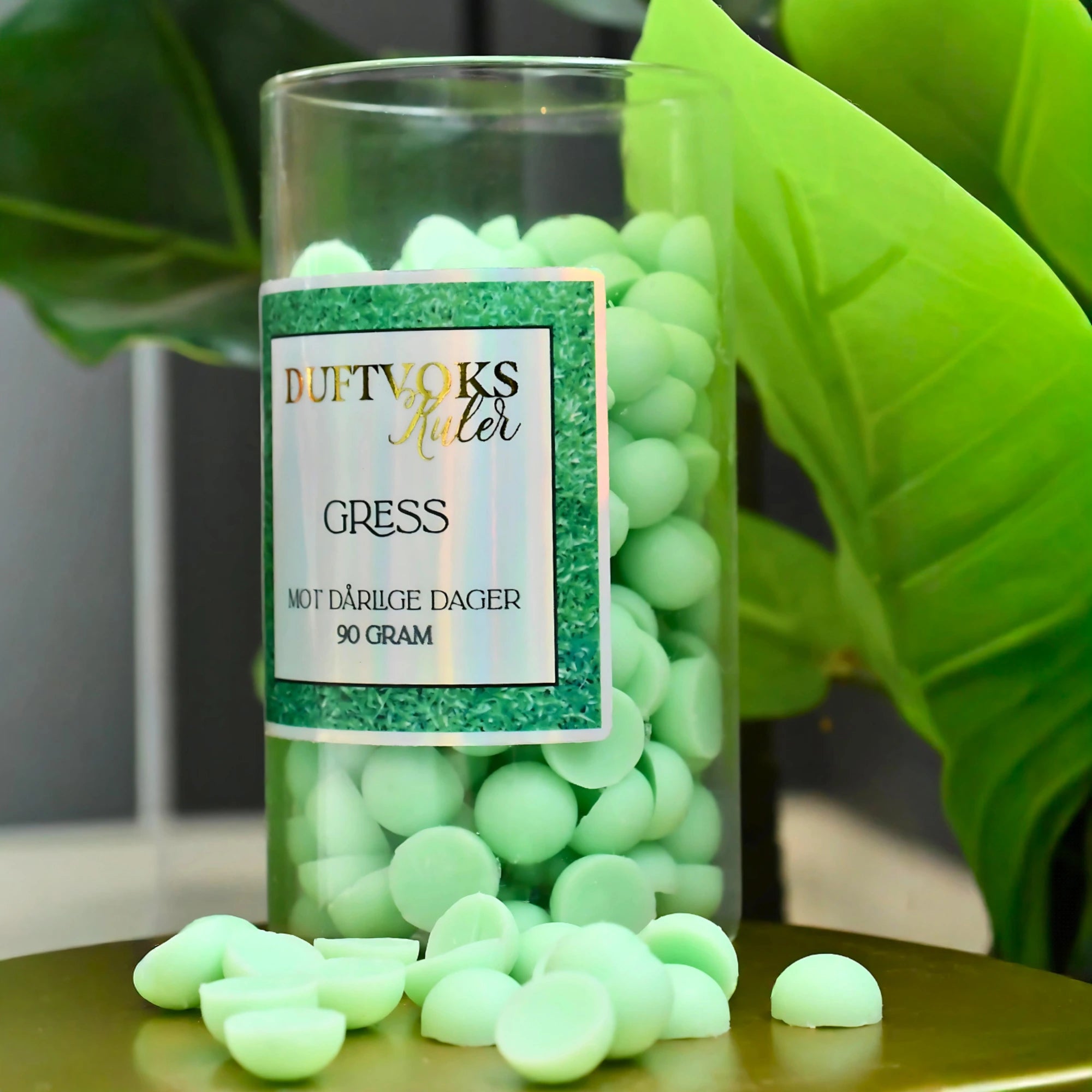 Glass krukke med 90 gram soyaduft voks i fargen grønn. Her ser man kulene ligge rundt krukken, klar til bruk.