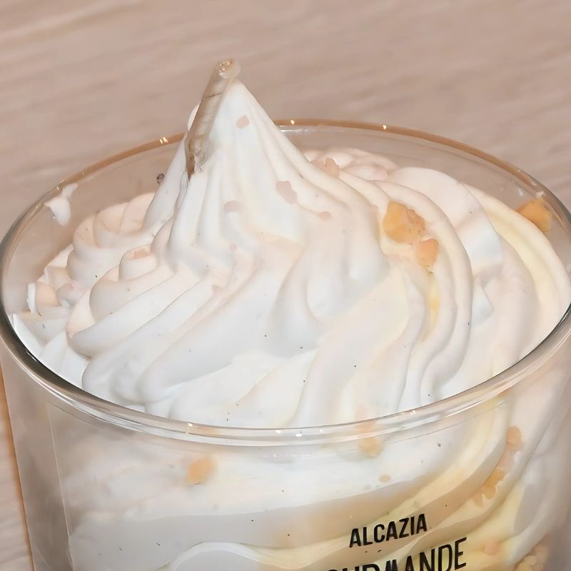 Nærbilde av toppen av duftlyset. Ser ut som en nydelig vaniljeis med granola strøssel.