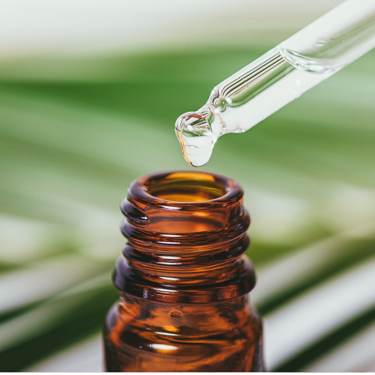 En pipette som viser en dråpe duftolje som helles over i glass.
