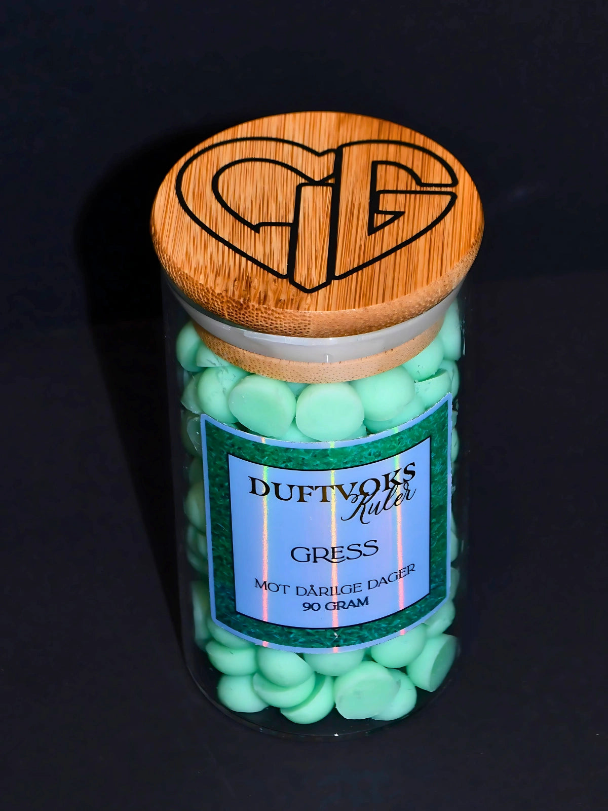 På toppen av glasset har vi hjertelig logoen. Duftvokskulene er laget av soyavoks og er håndlaget i Norge.