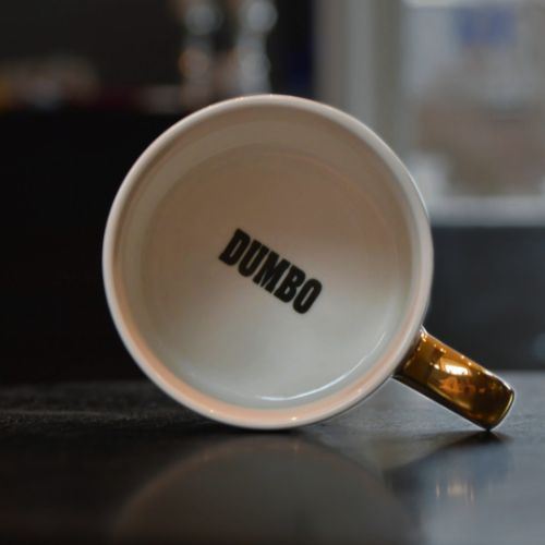 Oppi Dumbo kruset står teksten DUMBO med svart skrift.