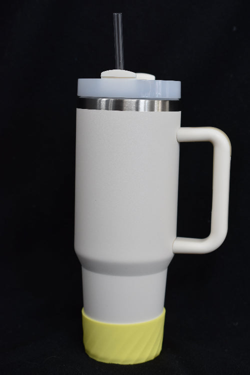 En gul mønstret silikonbeskyttelse som er festet på en termokopp. Beskytter termokoppen mot riper og skader.