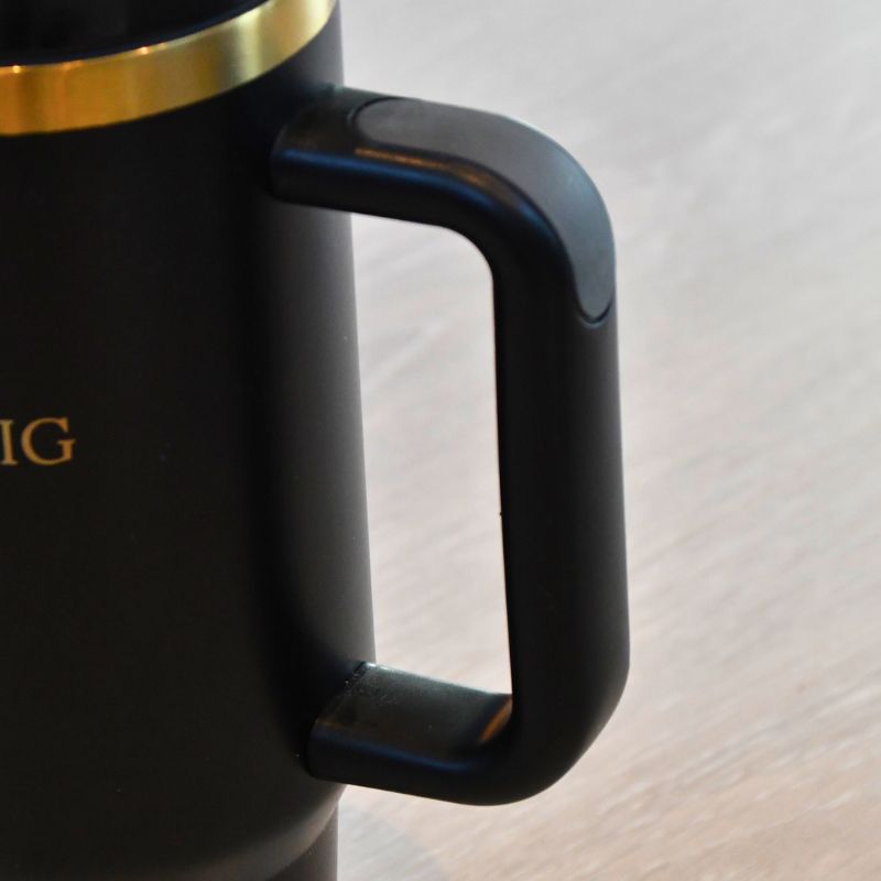 Håndtak til sort termokopp med silikonbelegg for bedre grep. Disse detaljene gjør at denne termokoppen skiller seg ut fra andre billige tumblere. Den har også veldig god isolasjon, så den vil holde drikken kald eller varm i overraskende mange timer. Gulldetaljene på den svarte koppen gir denne flasken et unikt og elegant utrykk og gjør den perfekt å gi bort i gave til noen som glemmer å drikke nok.