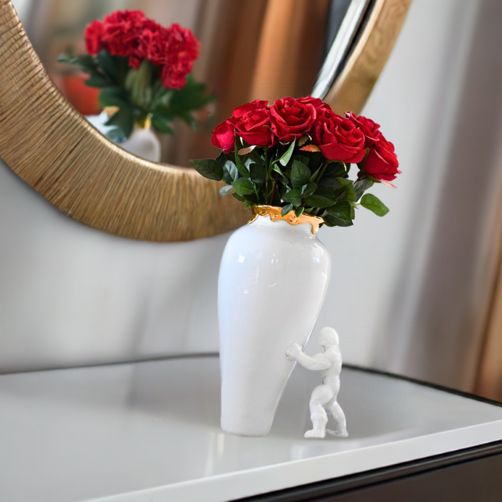 Hvit my superhero vase på komoden med et speil. Vasen har røde roser i seg.