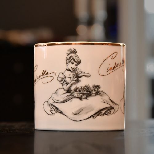 Askepott kopp. Koppen har forskjellige bilder på hver side. Dette er midten av koppen med Askepott som sitter på bakken i kjole