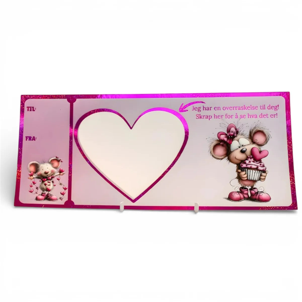 Kort til enhver anledning. Dette søte kortet har glitter rosa folie på seg som skinner når lyset treffer det. Det er noen søte mus på kortet med hjerter. Teksten på kortet er "Jeg har en overraskelse til deg! Skrap her for å se hva det er!" Det er en pil som peker mot hjertet som skal skrapes etter at teksten du ønsker er streket på og klistremerket er festet.