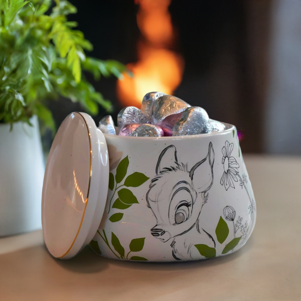 Krukke fra Disney med Bambi detaljer på. Her står den på bordet med lokket av forran en peis