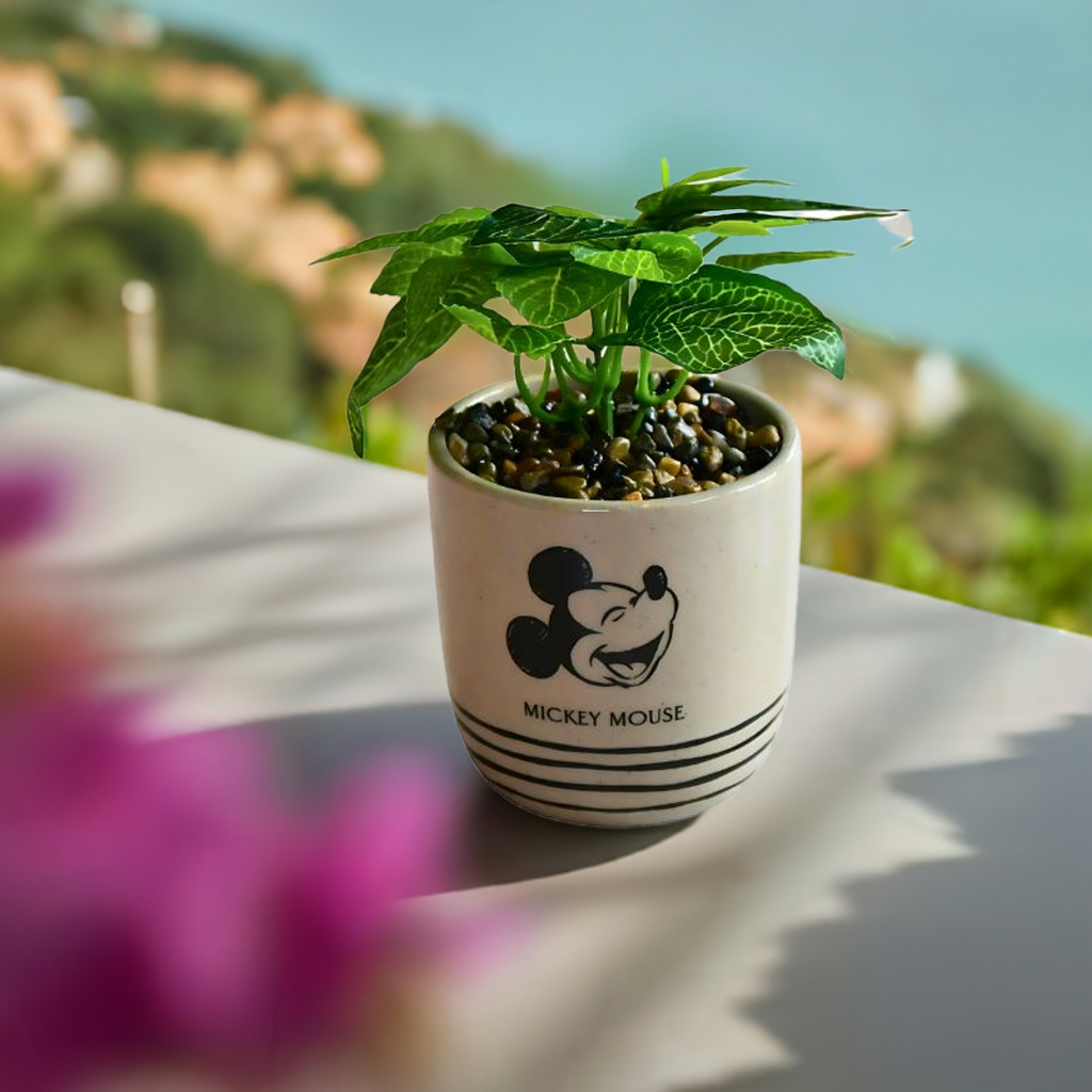 Mikke mus blomsterpotte som står ute i solen med en flott utsikt. Det er bilde av mikke mus på bomsterpotten og tekst