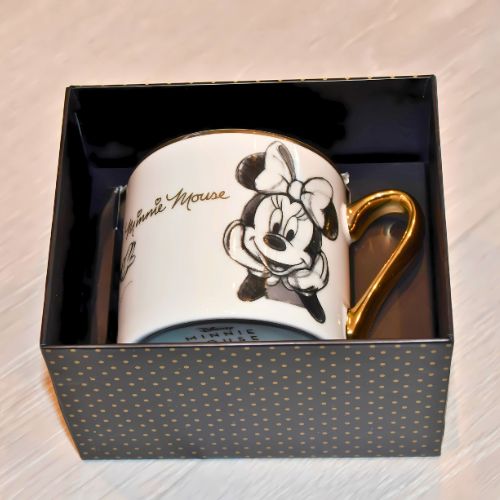 Minni mus krus i gave-esken sin med gulldetaljer akkurat som på koppen.