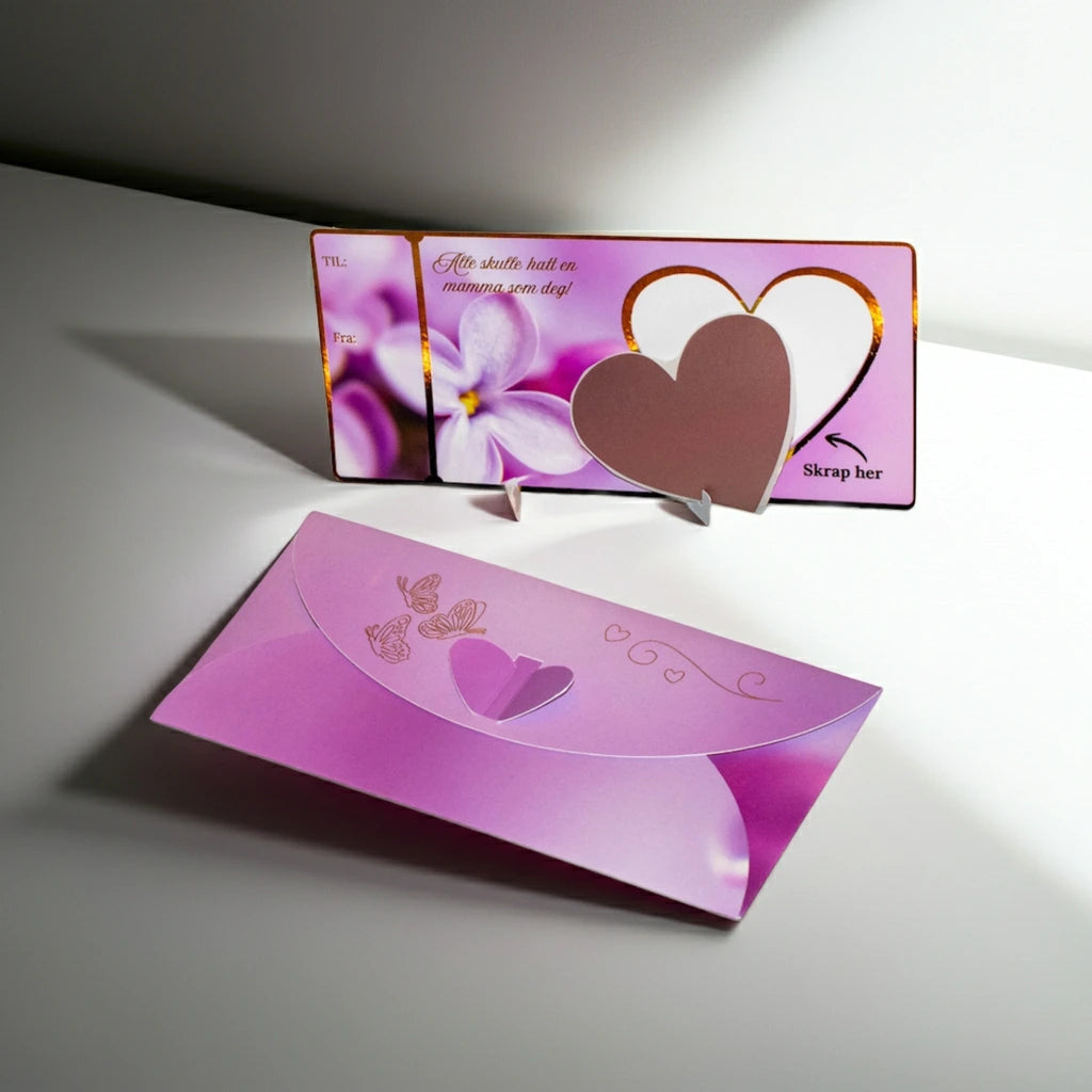 Håndlaget morsdagskort med nydelige gulldetaljer. Skrape klistremerke som følger med skal klistres over det hvite hjertet hvor du først skal skrive hva du ønsker å gi bort i morsdagsgave. Det kan være en opplevelse, et gavekort, en reise. Her er det bare fantasien som setter en stoppe. Unik og morsom måte å gi bort en helt spesiell gave på, til en helt spesiell mamma.