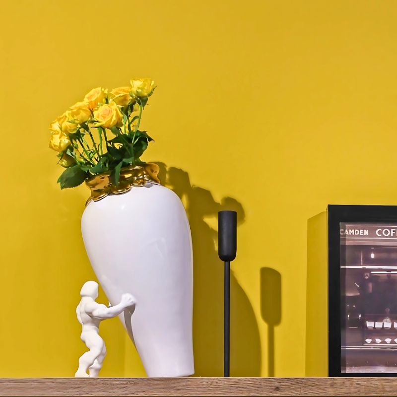 My superhero vase i hvit farge og 24 karat gull rundt toppkanten. Fylt med gule blomster for å sette påske stemning.