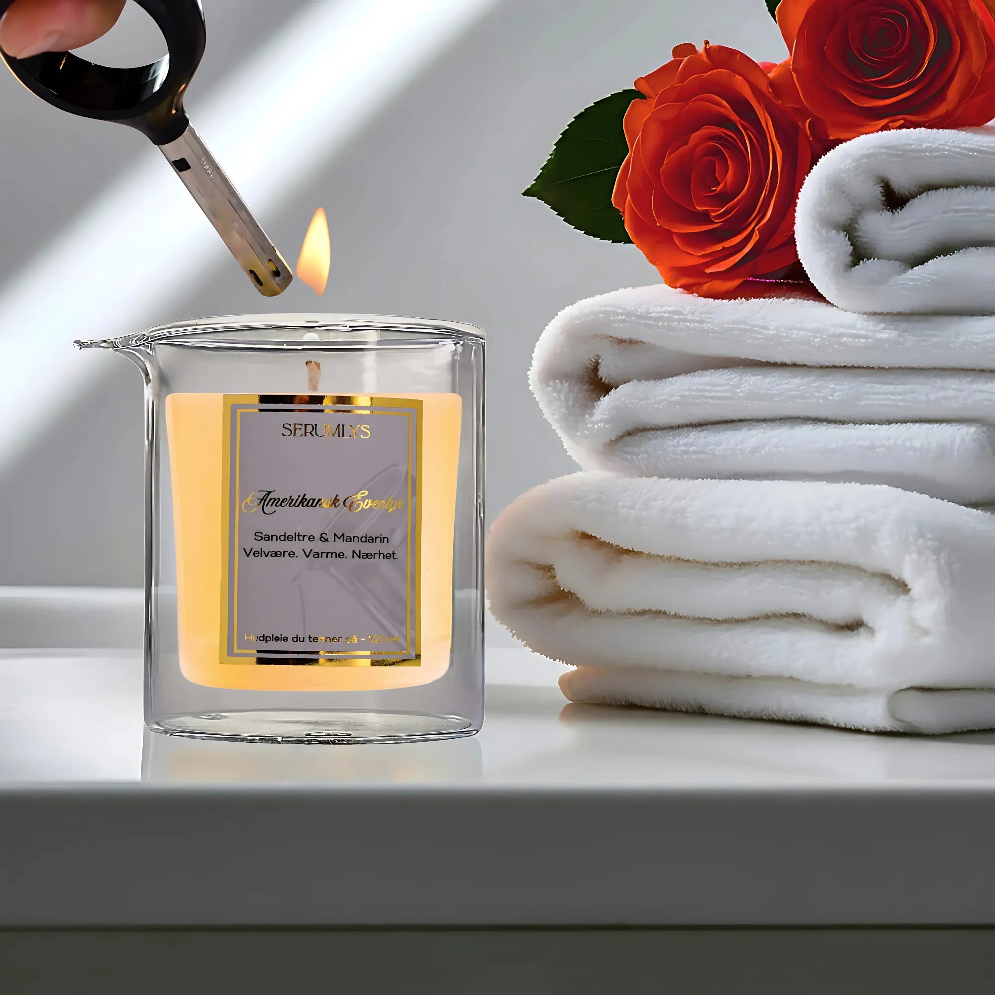 Naturlig hudpleie med næringsrike planteoljer. Maskulin duft av Sandeltre og mandarin. Lyset er i ferd ved å tennes. Ved siden av lyset ligger tre hvite håndklær med røde roser på toppen. Hudpleie som gir en luksuriøs følelse og velvære.