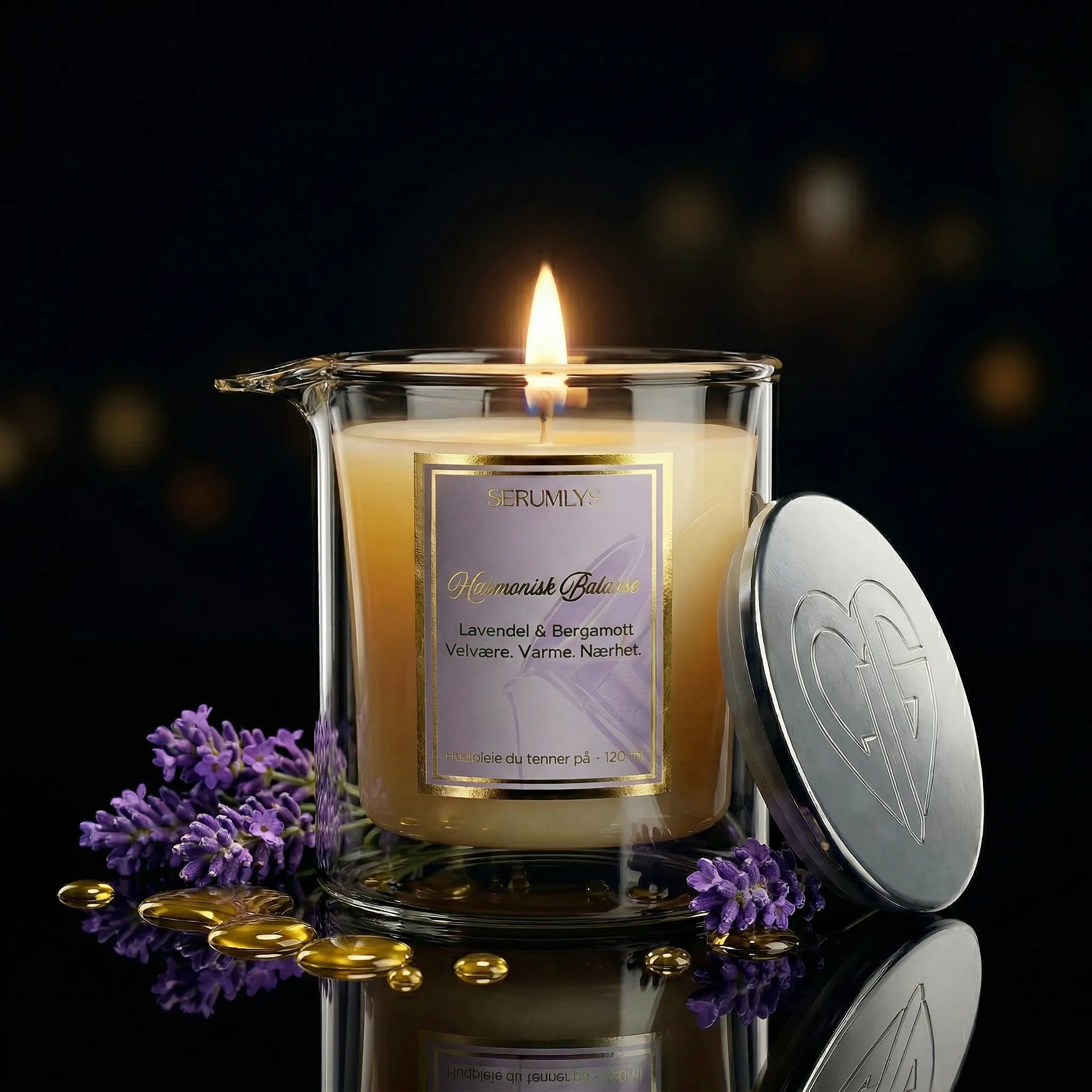 Serumlys er et hudpleieprodukt til hele kroppen. Denne varianten er med eterisk duftolje av lavendel og bergatmott. Et oppfriskende duft som passer like godt til henne som til han. Nydelige gulldetaljer og sølvlokk. Lyset står tent med lavendel blomst og noen dråper med serum rundt glasset. Glasset har helletut, og kan helles direkte fra glasset og på kroppen