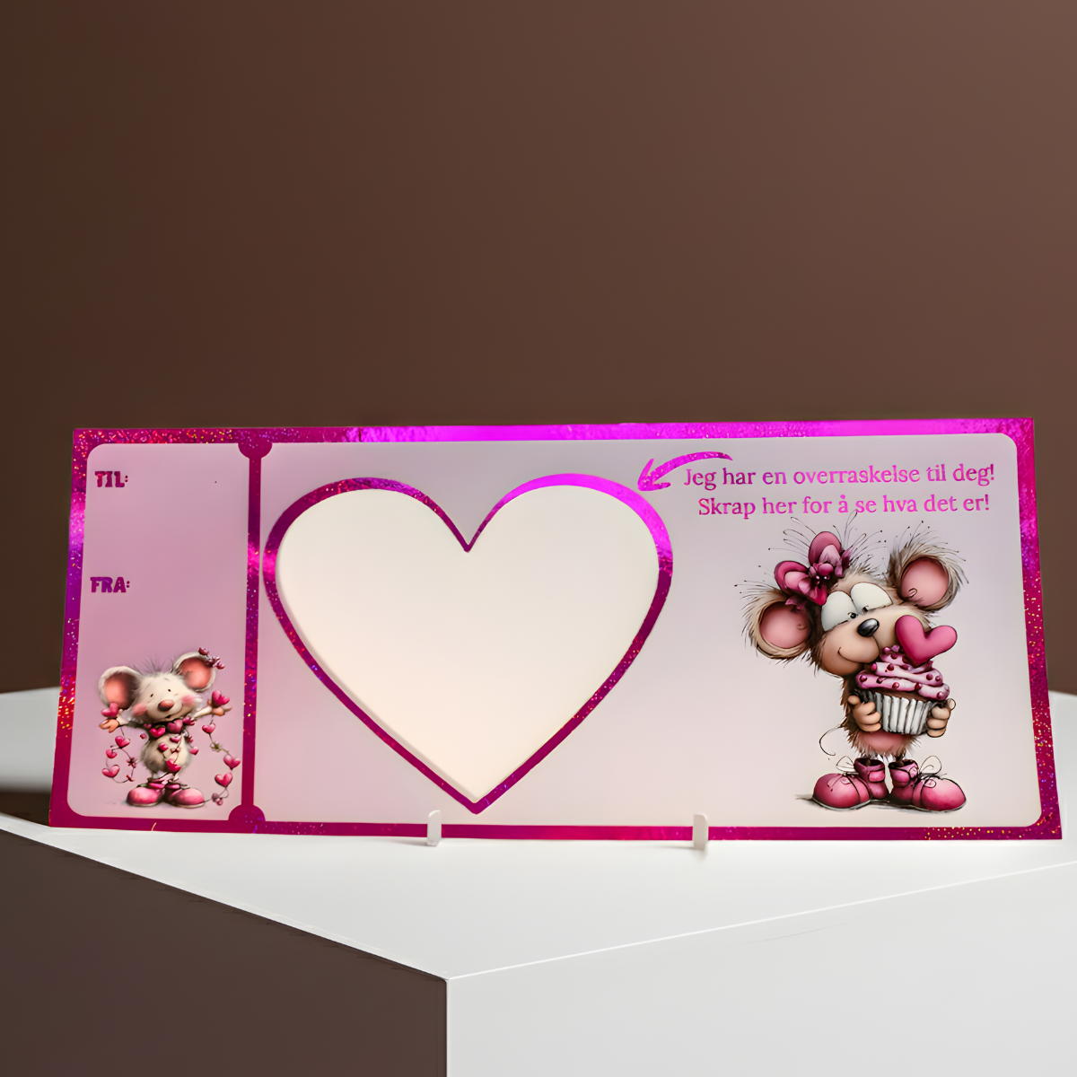 Håndlaget rosa glitter kort med nydelig design. Søte mus som holder kake og hjerter. Dette er kortet man gir til noen om man ønsker å gi bort noe helt spesielt i gave til en helt spesiell anledning. Her skal man skrive i hjertet hva man ønsker å gi bort, for så å putte klistremerke over teksten. Den som mottar kortet må skrape vekk hjertet akkurat som et flakslodd. Først når metal hjertet er skrapt bort kan man se hva man fikk! Unik og morsom måte å gi bort en opplevelse på.
