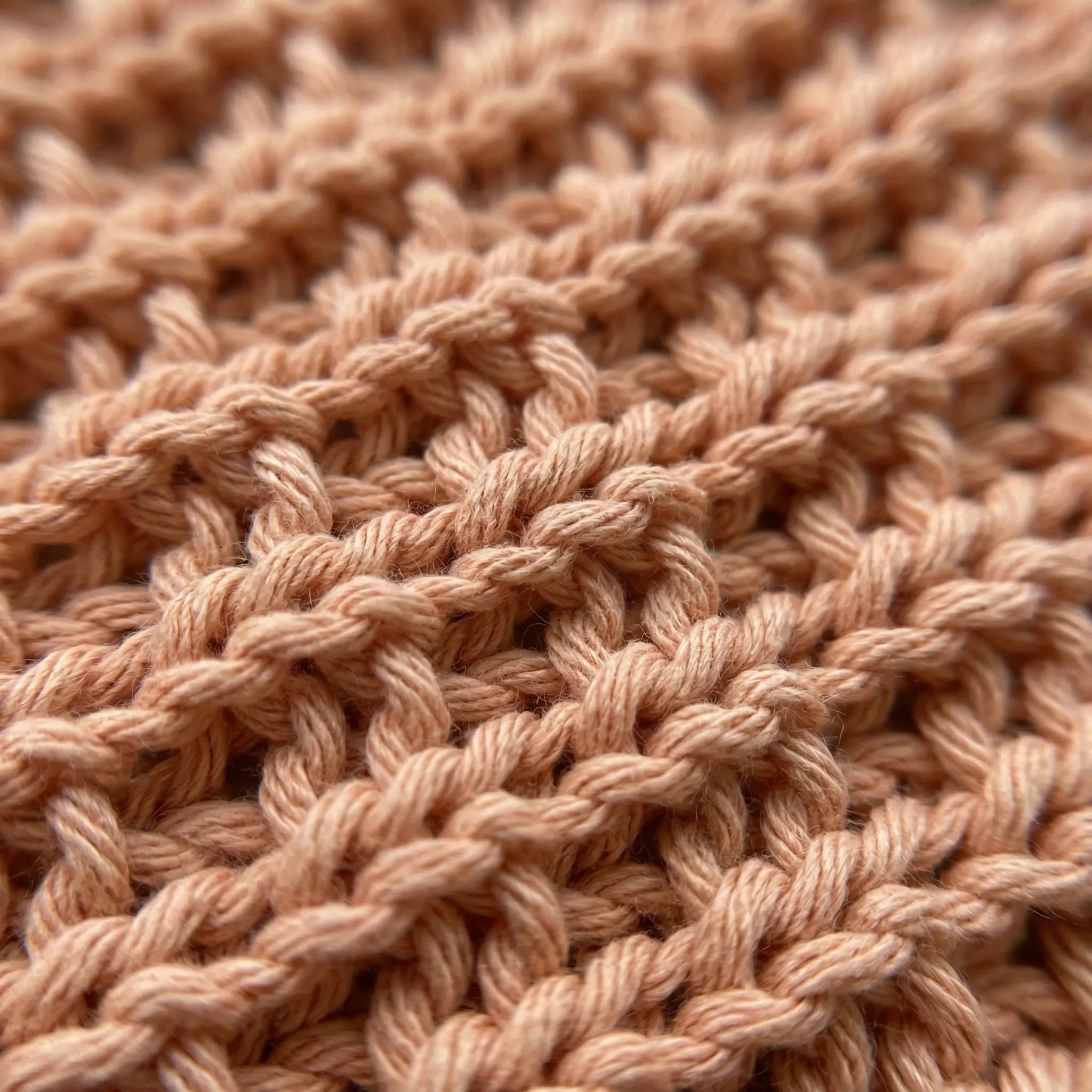 Strikket vaskekluter av 100% bomull. Her ser man detaljene og nærbilde av maskene og mønstret. Denne kluten er i fargen fersken som gir badet ditt en frisk detalj med sin nydelige farge.