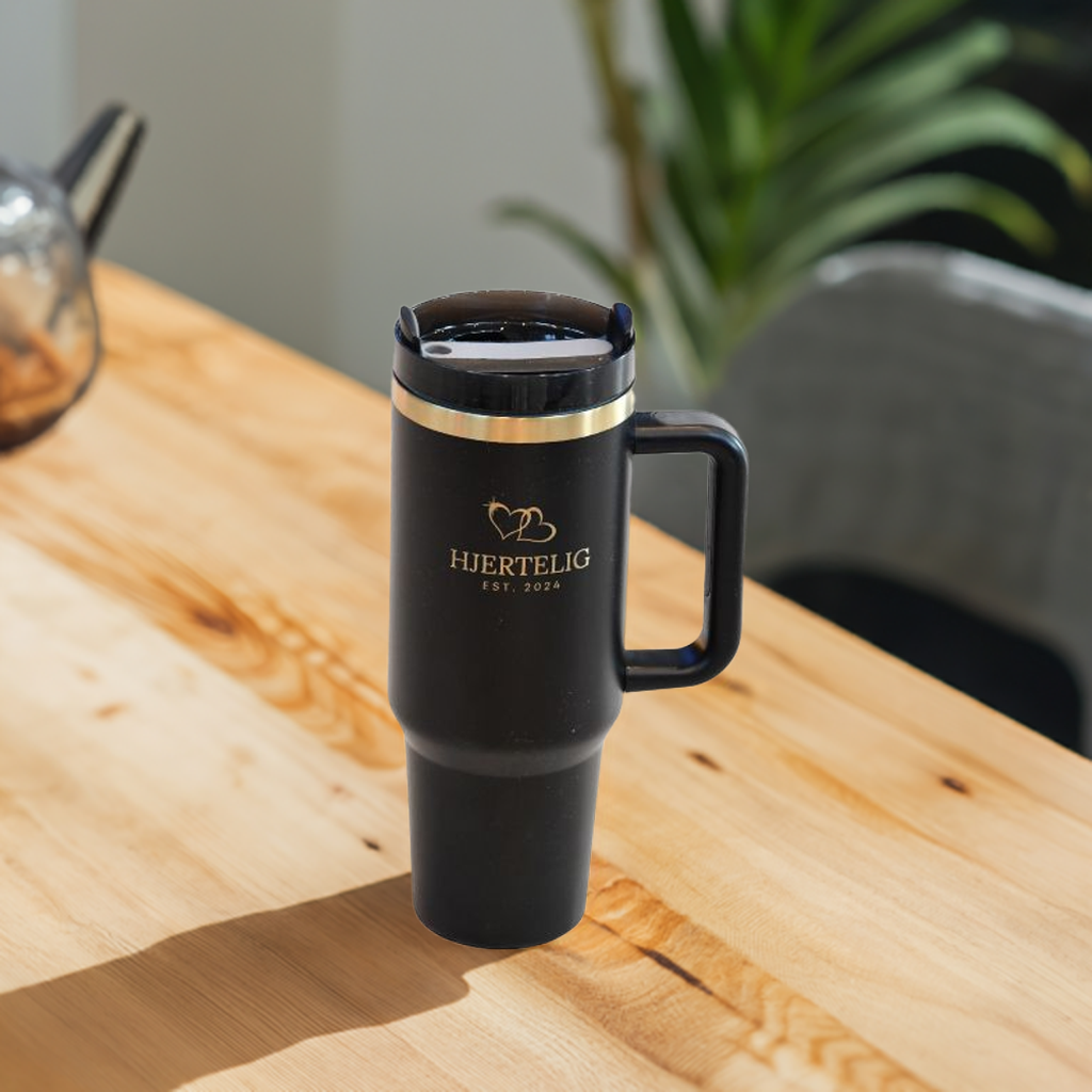 Svart hjertelig termokopp på kjøkkenbordet. Gulldetaljene og lasergraveringen gir flasken et ekslusivt preg som tar seg godt ut og blir lagt merke til. Svart og gull drikkeflaske som holder drikken kald eller varm overraskende lenge. Ikke bare ser denne koppen eksklusiv ut, den føles også ekslusiv. En detalj i hverdagen som kommer godt med.