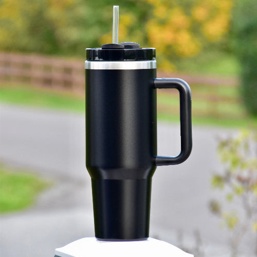Sort tumbler med sugerør og håndtak. Passer perfekt i koppholder i de fleste biler. 1,2 liter med drikke som med god isolasjon som holder varmen eller kulden på drikken inne. Kan lasergraveres. Designet i Norge. Personlig tekst på koppen gir den et unikt preg og er perfekt om man ønsker å gi bort en termokopp i gave.