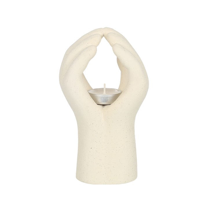 Hender som holder telys. Telysholder i keramikk i fargen beige. Man putter telyset i midten av hendene og dette gir en indre ro. Unikt design til et hvert hjem.