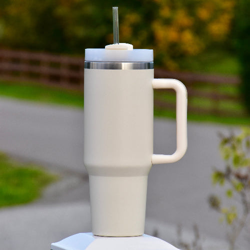 tumbler med håndtak og sugerør i beige farge. 1,2 liter med drikke igjennom dagen. Holder drikken kald eller varm. Lasergravering om ønskelig. Silikongrep. Designet i Norge. Personlig gave med laser gravert tekst om man ønsker.