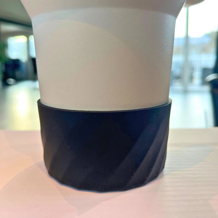 En beskyttelse med stripet mønster i sort farge til termokopper. Beskytter termokoppen din mot riper og andre skader. Uansett om beskyttelsen er på termokoppen, så vil den fortsatt passe fint i universale koppholdere.