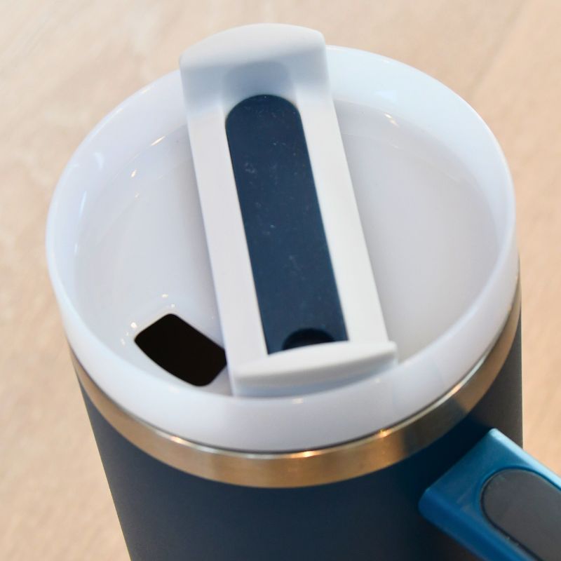 Lokket til den blå tumbleren. Flasken har et lokk med avtagbare deler som gjør den enkel å reingjøre. Velg mellom å bruke sugerør eller hullet til å drikke av. Perfekt for å holde både varm og kalde drikker i ønsket temperatur i timesvis. Snurr på delen i midten og den vil holdes tett.