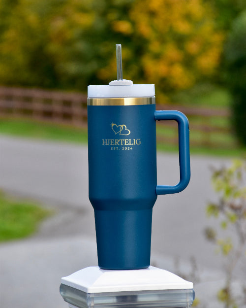 Tumbler med sugerør og håndtak i blå farge med gullkant og logo