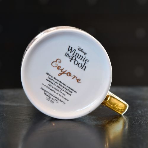 Undersiden av Disney kruset. Med svart og gull skrift som matcher resten av koppen