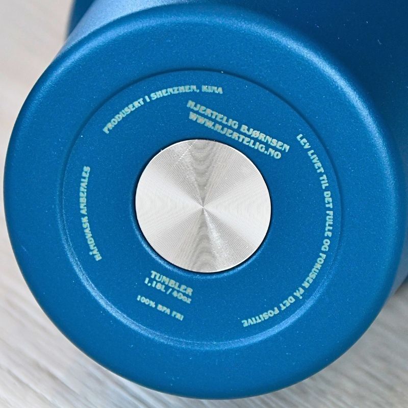 Under den blå teremokoppen informasjon. Her ser man hvor termokoppen er produsert og designet. Det står også en fin og inspirerende tekst "lev livet til det fulle og fokuser på det positive" En liten påminnelse i en hektisk hverdag.