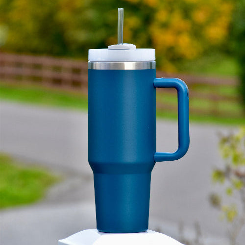 Stor blå tumbler med sugerør og håndtak. God kvalitet termokopp som holder drikken kald eller varm i mange timer. Passer perfekt i koppholderen i bilen, og du vil ha 1,2 liter med drikke gjennom dagen. Personlig gave med valgfri tekst