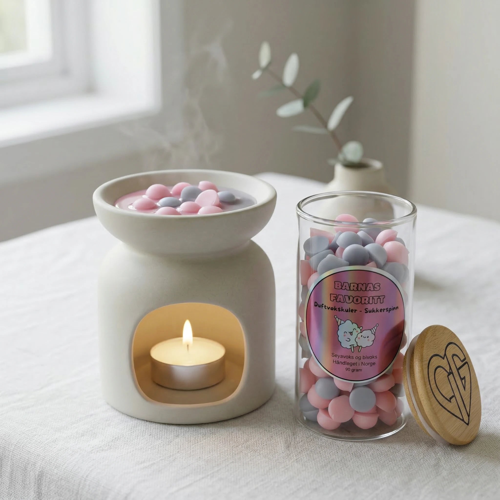 Duftvoks laget av bivoks og soyavoks. Voksen smelter i en duftbrenner som sprer herlig duft av sukkerspinn ut i rommet. En duft som minner om de lekne dagene med tivoli og karuseller. Håndlaget i Norge. Hvert glass inneholder 90g voks. Glasset har et trelokk med Hjertelig AS sin logo.