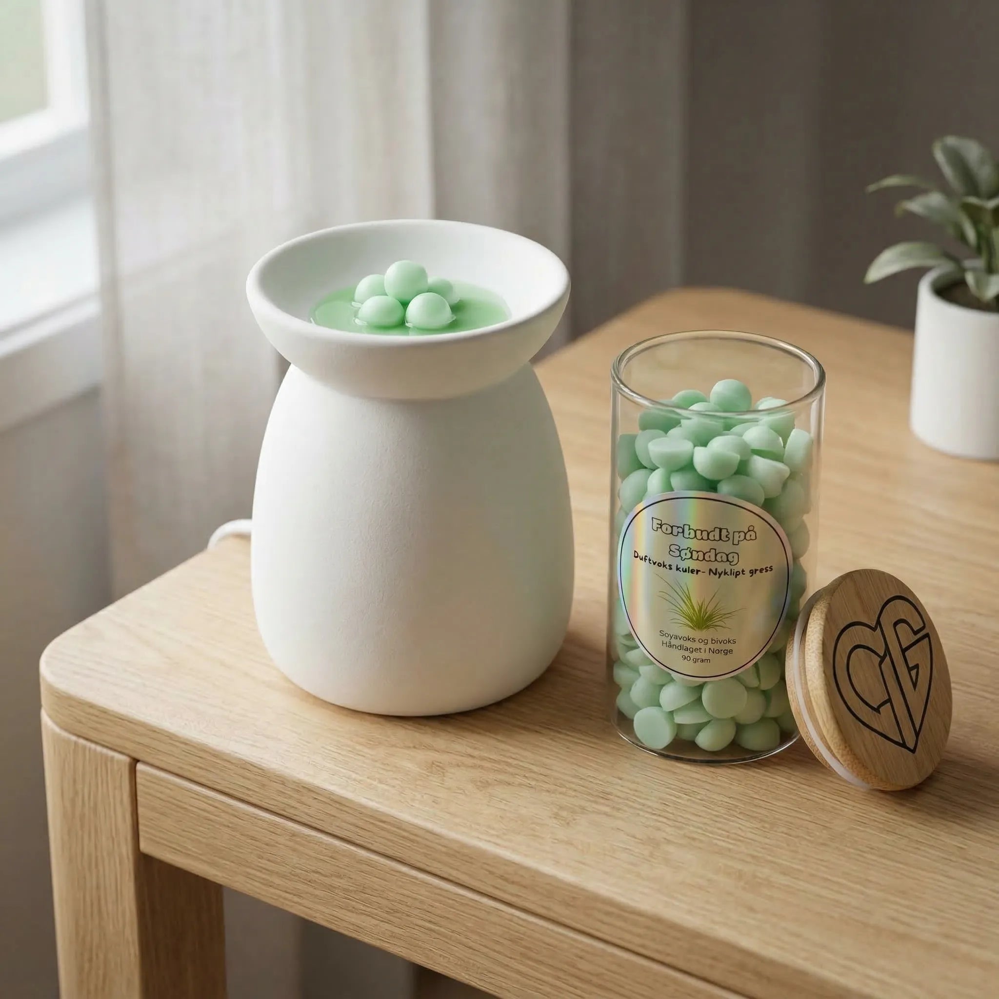 Duftvokskuler med duft av nyklipt gress som heter forbudt på søndag. Noen vokskuler er lagt i en duftbrenner som smelter voksen, slik at den lette og friske duften av nyklippet gress kommer ut i rommet. Håndlaget i norge. Hvert glass inneholder 90g med voks.