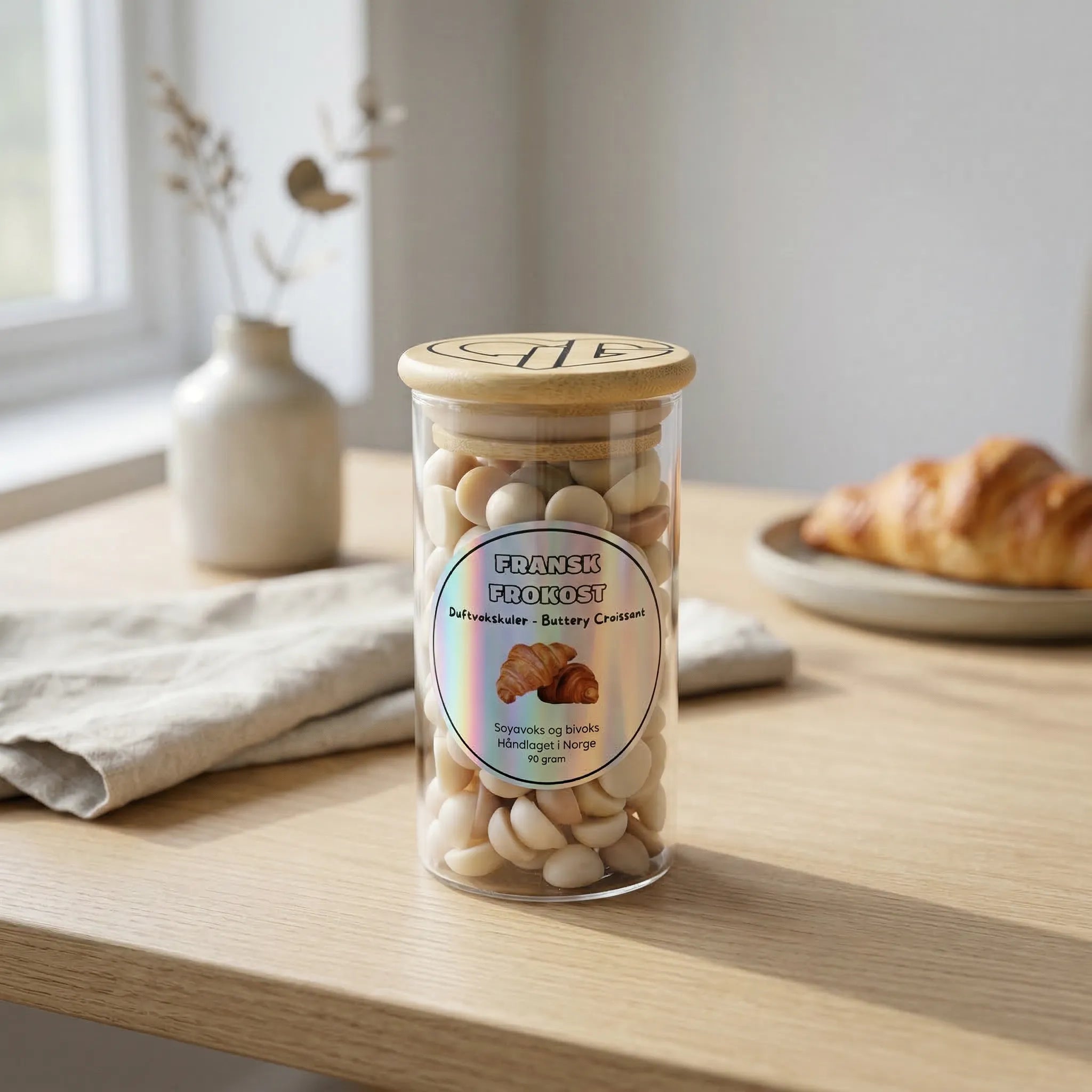 Små brune og beige duftvokskuler i et glass med trelokk. Fransk frokost har duft av nystekt croissant. Til bruk sammen med en duftbrenner for å spre herlig duft i hjemmet.