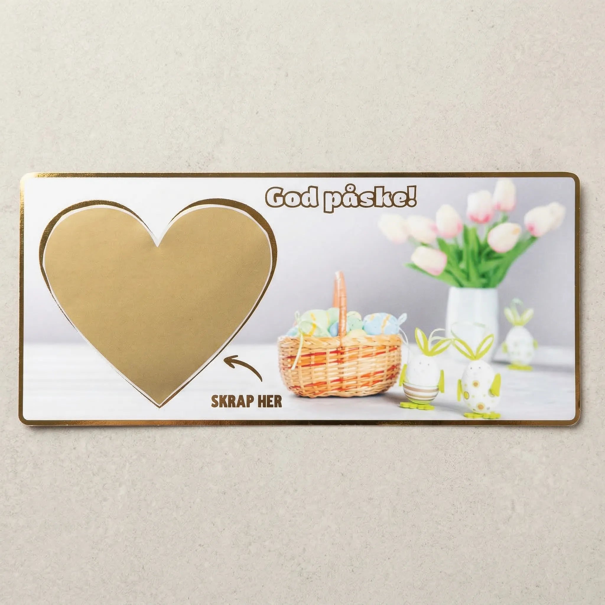Et kort til påske med skrapefelt. Skriv inn gaven du vil gi og fest over skrapelappen. Påskeliljer og påskeegg design, med teksten God påske og skrap her. Gullfolierte kanter. Håndlaget i norge.
