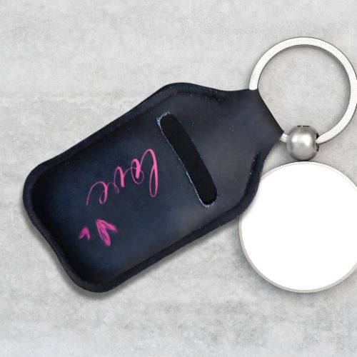 Håndlaget sort veske med rosa tekst og hjerter til airpods som brukes som en nøkkelring