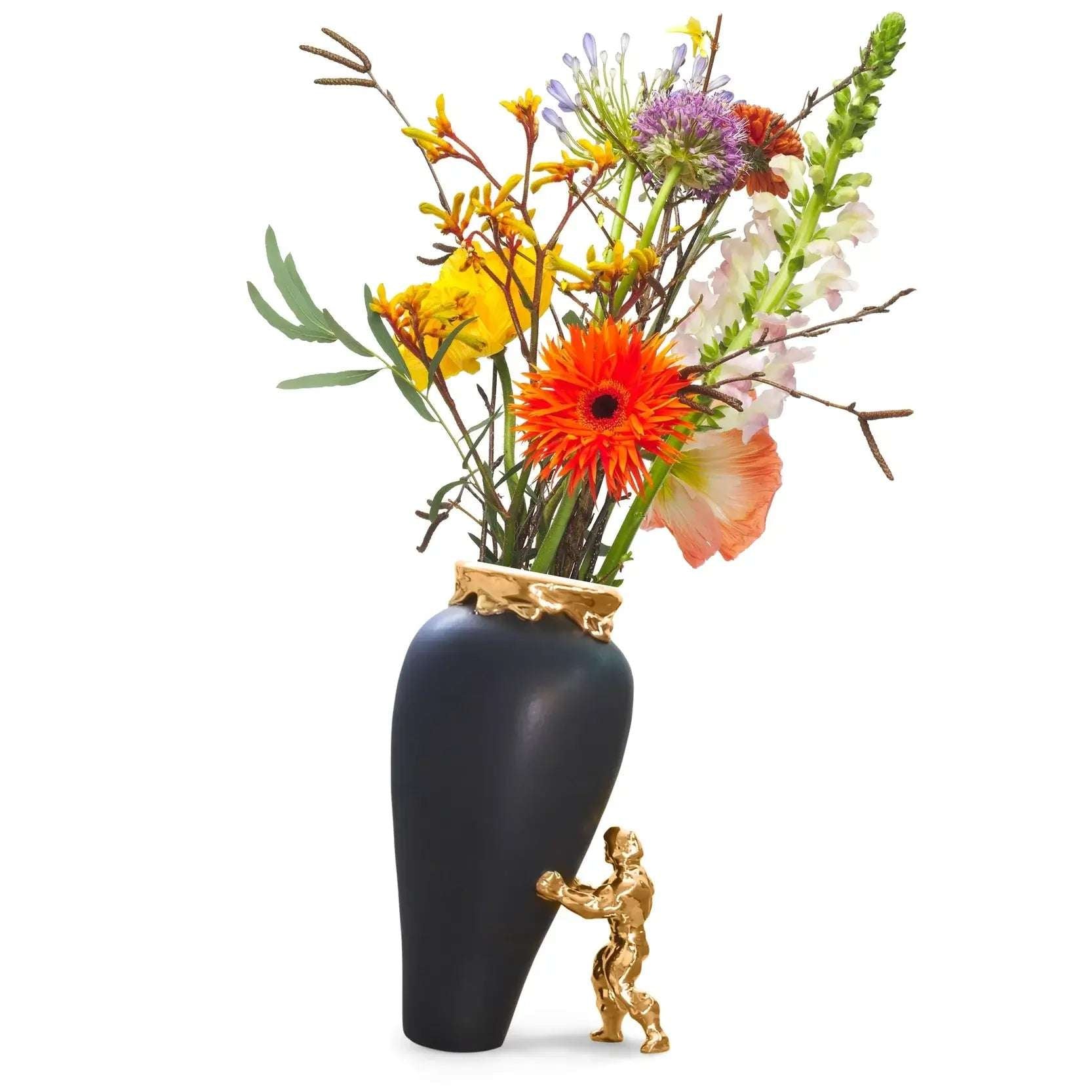 en superhelt som støtter opp den sorte vasen med fargerike blomster. Vasen er håndlaget i nederland og kommer i sort farge med gullkant. Superhelten som gullfarget. Dette her er virkelig et kunstverk som garantert vil bli et blikkfang i rommet.