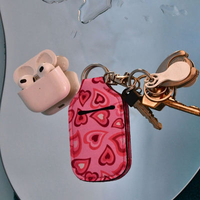 Airpodsveske som henger på nøkkel-knipe med airpodsene vesidenav. 