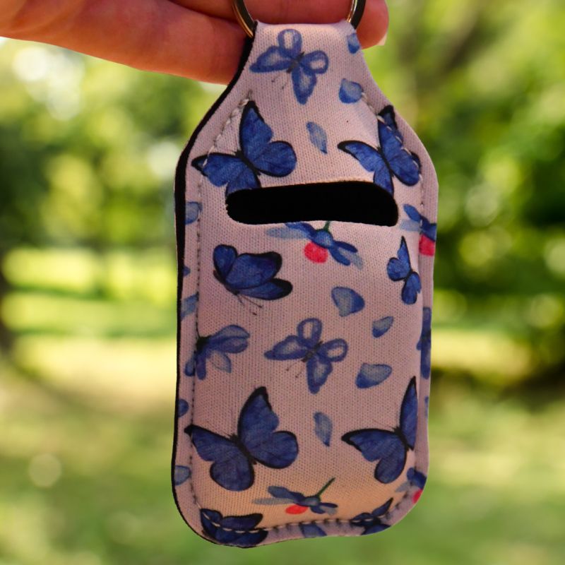 Veske til airpods med blåe sommerfugler på. Her er nærbilde av vesken til airpodsene. Dette er en perfekt gave til noen som alltid roter bort airpodene sine. Her har du full kontroll på hvor de er til en hver tid. Bruk nøkkelring kroken til å henge vesken på ting du alltid har med deg i farten. 