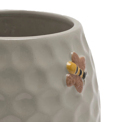 Honningkrokke blomsterpotte med bie detaljer. Her er nærbilde av toppen av blomsterpotten. Nydelige detaljer og bier rundt potten. 