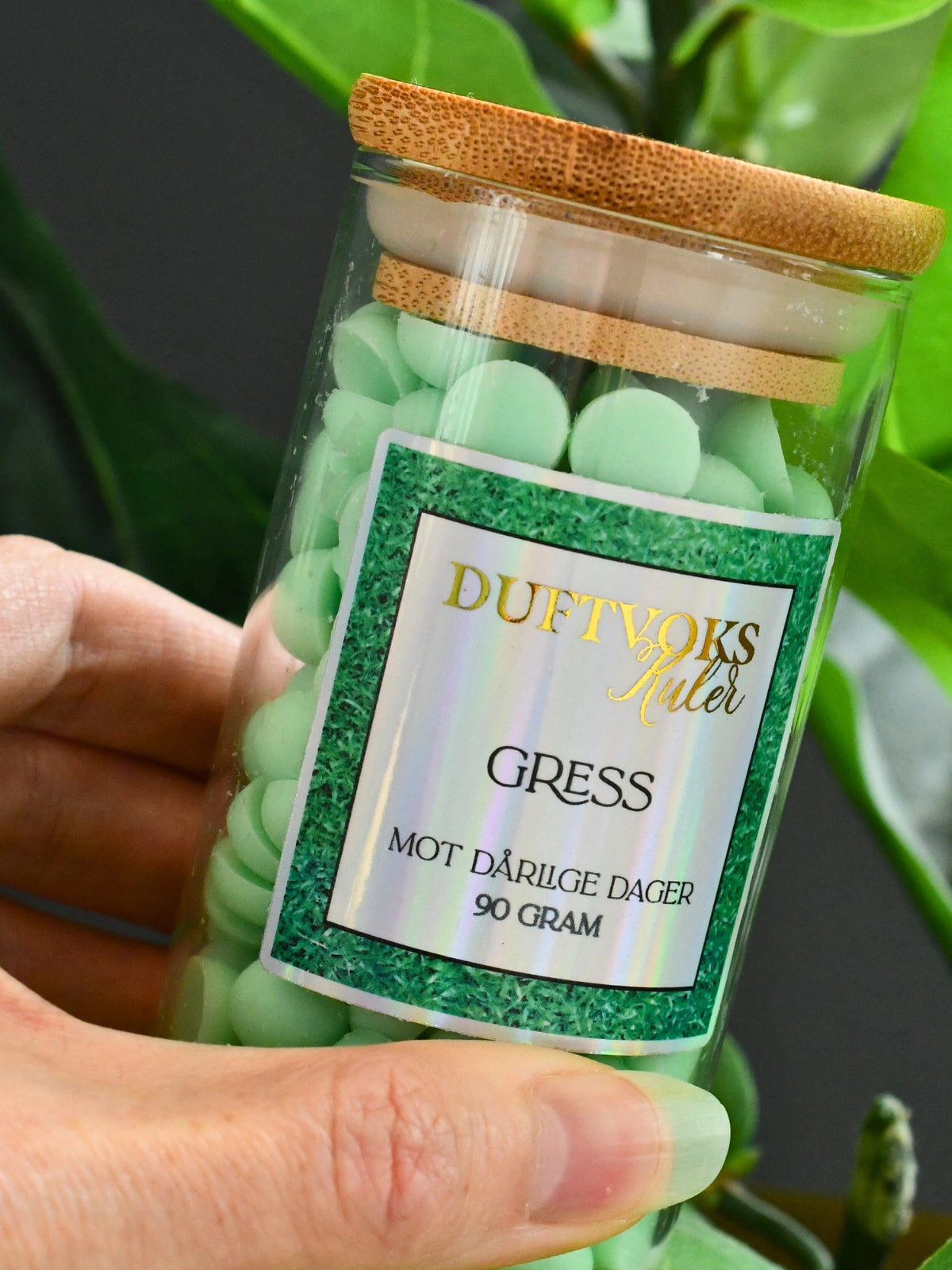 Glass krukke med 90gram duftvoks laget av soyavoks. Glasset blir holdt her og tar seg godt ut som en del av stue interiøret. 