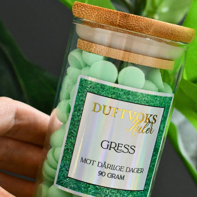 Glass krukke med 90gram duftvoks laget av soyavoks. Glasset blir holdt her og tar seg godt ut som en del av stue interiøret. 