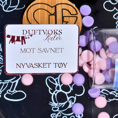 Framsiden av duftvoks kule kortet mot savnet. Kulene er rosa og lilla. Fyll rommet med duften av nyvasket tøy. Ting blir bedre, bare gi det tid. 