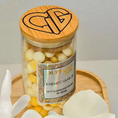 Duftvoks med lukten av kremet vanilje. Til duftbrenner. Kommer i denne nydelige glasskrukken med bambuslokk. Flott decor til hjemme, itillegg til at hjemmet omringes av en herlig vanilje duft ved bruk av noen duftkuler i duftbrenner. 