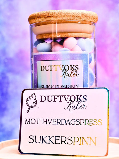 Duftvoks kuler i glasskrukke med lokk. Disse soyavoks kulene har en herlig lukt av sukkerspinn. Nostalgi og barndom. Vi har dedikert denne duften til de som er i en periode med mye hverdagspress. Man blir presset både i jobbsammenhenger og hjemme. Da kan det være godt å bruke litt tid på seg selv. Smelt noen kuler og bare vær deg. Egentid er også viktig. 