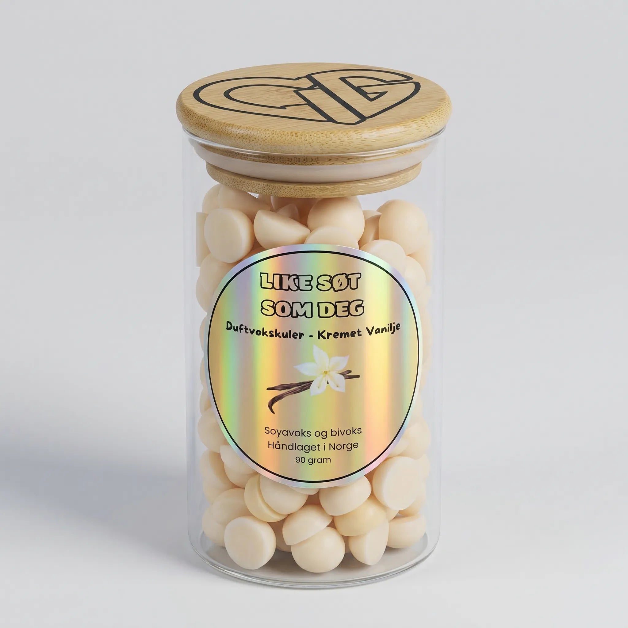 Duftvokskuler i glass. Like søt som deg er duftvoks laget av soyavoks og bivoks, med en søt duft av kremet vanilje. Glasset har trelokk med Hjertelig AS sin logo og inneholder 90g voks.