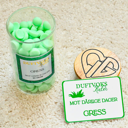 Soya voks kuler på teppet med lokket av. Duftvoks følelseskortet ligger vedsiden av. Dette er framsiden av følelseskortet som følger med. Perfekt til noen som har dårlige dager, og trenger en trøst eller oppmerksomhet.