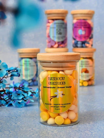 Håndlaget duftvoks kuler i fargen krem og gul. Disse kulene gir en herlig duft av kremete vanilje som fyller hele rommet når de puttes i duftbrenneren. De kommer i en nydelig glasskrukke, og på den står det "like søt som deg"